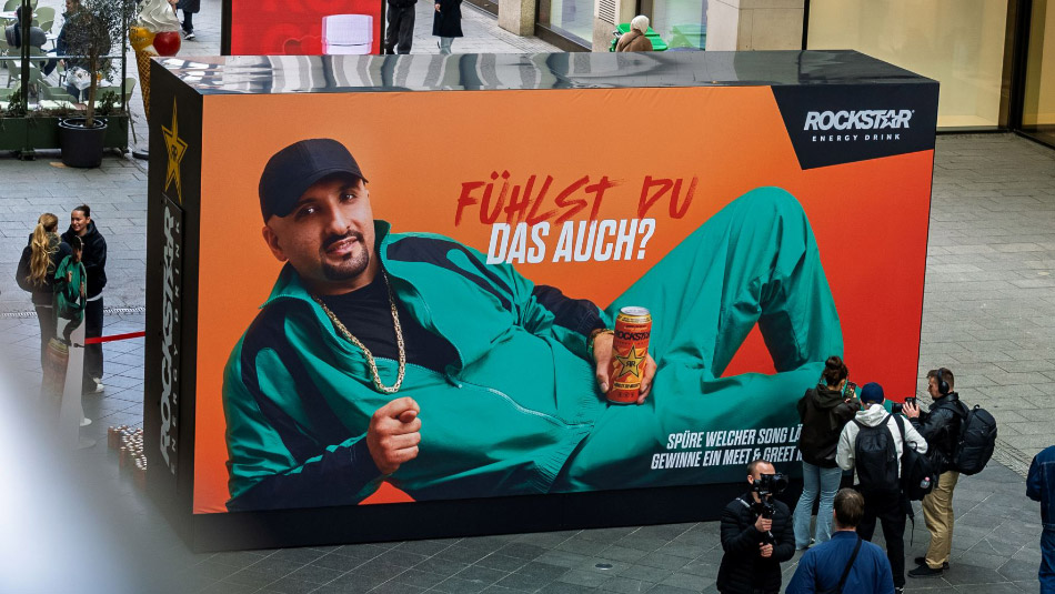Die Out-of-Home-Installation mit dem Rapper SSIO ist Teil der ‚Musik im Blut‘-Kampagne der Pepsico-Marke Rockstar. Mit dem Rapper zeige die Marke, dass Musik ein Gefühl und damit mehr sei als ein Genre. Das Billboard übersetzt diese Haltung in die analoge Welt: Musik wird greifbar, erlebbar und überraschend persönlich. Foto: Pepsico/Rockstar