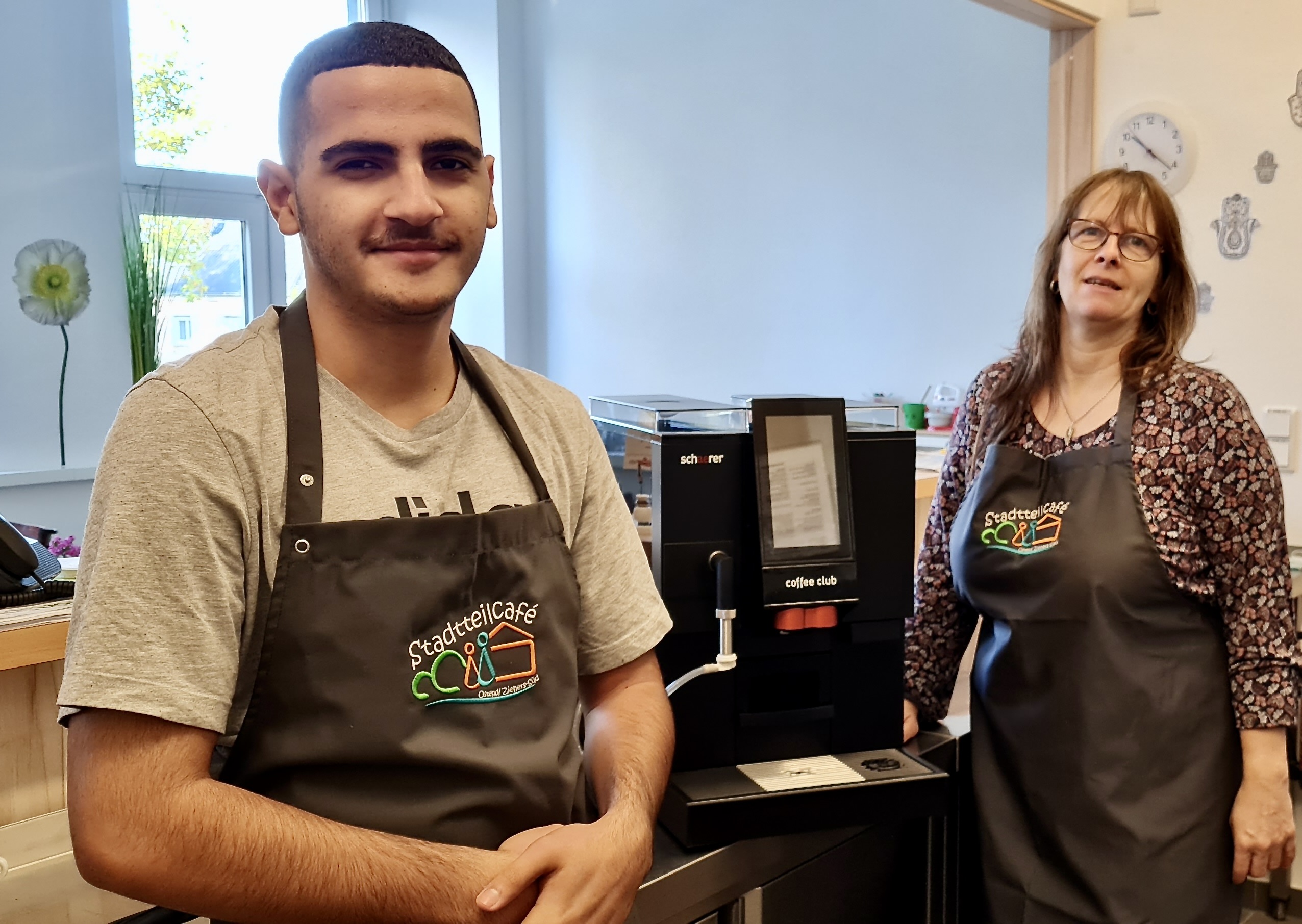 Ayoub Salim, ehrenamtlicher Helfer im Stadteilcafé, und Marina Spuck, Vorstandsmitglied beim Mütterzentrum, freuen sich über den gespendeten Schaerer-Vollautomaten Coffee Club. Foto: Schaerer